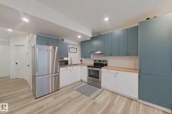 Modern kitchen featuring two-tone cabinetry with wood-finish countertops - 