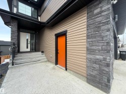 Contemporary exterior featuring horizontal siding in a neutral tone, complemented by dark stacked stone accents - 