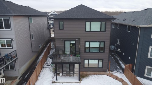 Contemporary three-story residence featuring dark siding, a private rear deck, and a ground-level patio - 1210 Peregrine Terrace, Edmonton, AB - Outdoor
