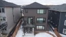 Contemporary three-story residence featuring dark siding, a private rear deck, and a ground-level patio - 1210 Peregrine Terrace, Edmonton, AB  - Outdoor 