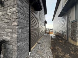 Exterior wall featuring stacked stone veneer and horizontal siding - 