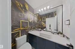 Powder room featuring a large rectangular mirror, vessel sink, and a blue base vanity with a white countertop - 
