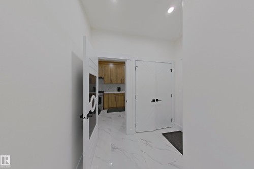 Bright hallway with white walls, recessed lighting, and large format marble-look tile flooring - 1210 Peregrine Terrace, Edmonton, AB - Indoor Photo Showing Other Room