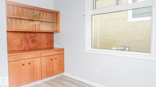 Built-in wood cabinetry with upper glass-front display shelves, lower storage cabinets, and drawers - 11131 52 Street, Edmonton, AB - Indoor Photo Showing Other Room