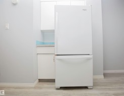 White bottom-freezer refrigerator paired with white cabinetry - 