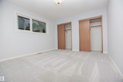 Spacious room featuring light grey carpeting, white baseboards, and light grey painted walls - 
