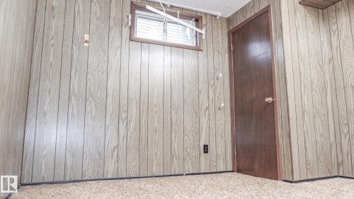 Paneled walls with wood-finish texture, presenting a window with horizontal blinds - 11131 52 Street, Edmonton, AB - Indoor Photo Showing Other Room