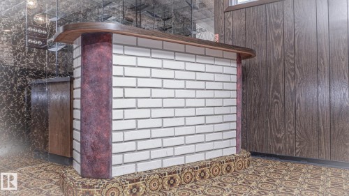 Built-in bar featuring white brick detailing, a wood-finish countertop, and decorative patterned flooring - 11131 52 Street, Edmonton, AB - Outdoor