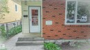 Brick and siding exterior featuring a white entry door with a glass insert, a concrete front step, and a window with white trim - 11131 52 Street, Edmonton, AB  -  With Exterior 