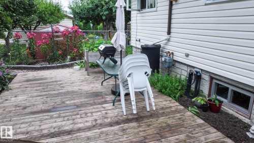 Spacious wood-finish deck bordered by a planting bed - 11131 52 Street, Edmonton, AB - Outdoor With Deck Patio Veranda With Exterior