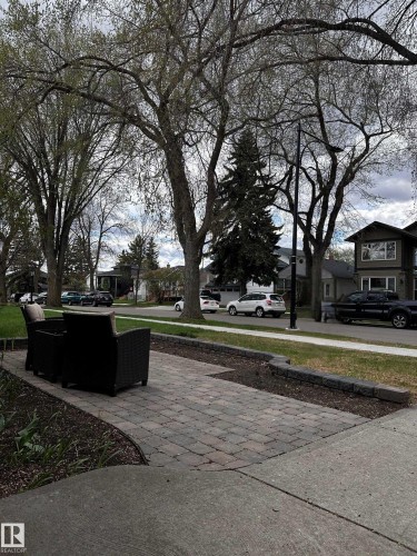 Paver patio area with a stone retaining wall and mature trees - 11131 52 Street, Edmonton, AB - Outdoor