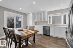 Kitchen featuring white cabinets, a textured ceiling, glass insert cabinets, stainless steel appliances, and recessed lighting - 