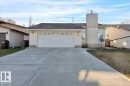 View of front facade featuring a chimney, driveway, stucco siding, a garage, and a front yard - 3515 20 Avenue, Edmonton, AB  - Outdoor 