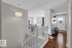 Hall with an upstairs landing, dark wood-type flooring, a textured ceiling, and recessed lighting - 