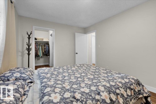 Bedroom with a textured ceiling, wood finished floors, and a walk in closet - 3515 20 Avenue, Edmonton, AB - Indoor Photo Showing Bedroom