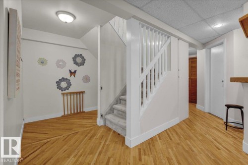 Staircase featuring a paneled ceiling and wood finished floors - 3515 20 Avenue, Edmonton, AB - Indoor Photo Showing Other Room