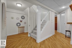 Staircase featuring a paneled ceiling and wood finished floors - 