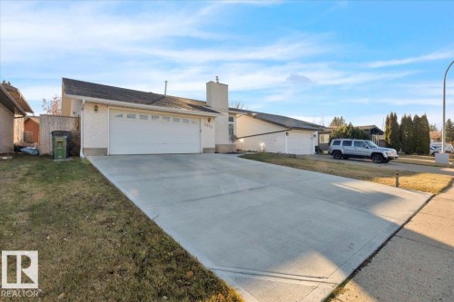 Ranch-style home featuring a chimney, concrete driveway, and a front yard - 3515 20 Avenue, Edmonton, AB - Outdoor