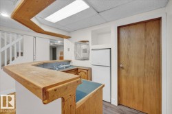 Kitchen with freestanding refrigerator, a drop ceiling, wood finished floors, and butcher block counters - 