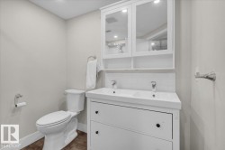 Bathroom featuring tasteful backsplash, double vanity, and dark tile patterned flooring - 