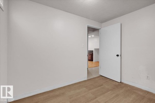 Carpeted spare room featuring a textured ceiling and baseboards - 3515 20 Avenue, Edmonton, AB - Indoor Photo Showing Other Room