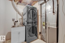 Washroom featuring estacked washer and dryer, heating unit, and light flooring - 