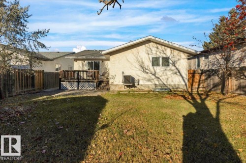 Back of house featuring a fenced backyard, a wooden deck, and stucco siding - 3515 20 Avenue, Edmonton, AB - Outdoor With Deck Patio Veranda