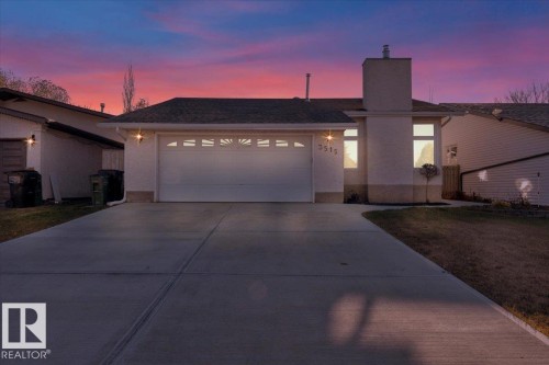 View of front of home with a chimney, driveway, a garage, stucco siding, and a yard - 3515 20 Avenue, Edmonton, AB - Outdoor