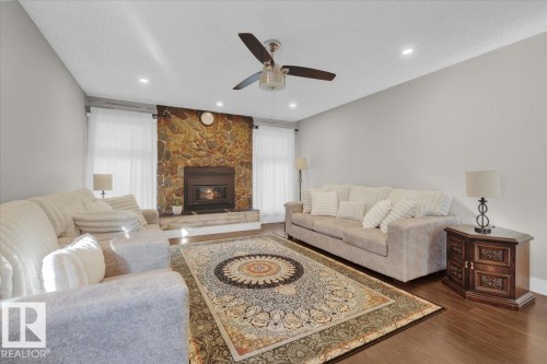 Living area featuring dark wood finished floors, a fireplace, recessed lighting, a textured ceiling, and ceiling fan - 3515 20 Avenue, Edmonton, AB - Indoor Photo Showing Living Room With Fireplace