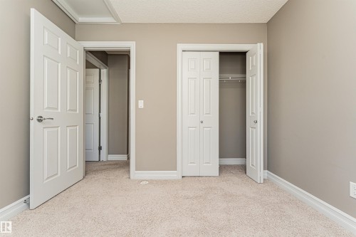 Neutral tone wall finishes, white trim, and light-toned carpeting define this interior space - 110 3625 144 Avenue, Edmonton, AB - Indoor Photo Showing Other Room