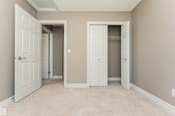 Neutral tone wall finishes, white trim, and light-toned carpeting define this interior space - 
