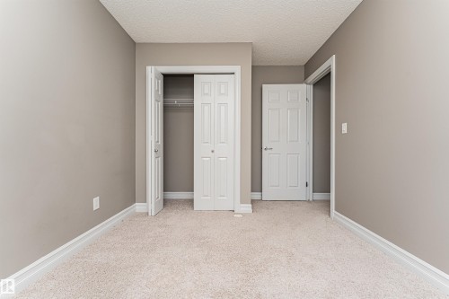 Neutral-toned walls and plush carpeting - 110 3625 144 Avenue, Edmonton, AB - Indoor Photo Showing Other Room
