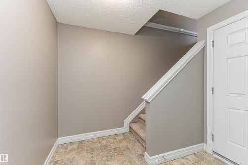 Entryway featuring a white paneled door, neutral wall color, and patterned floor tiles - 110 3625 144 Avenue, Edmonton, AB - Indoor Photo Showing Other Room