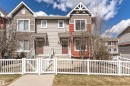 Contemporary townhome exterior featuring multi-toned siding, stone accents, and a front entry with white railing and gate - 110 3625 144 Avenue, Edmonton, AB  - Outdoor With Facade 