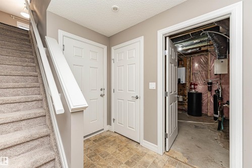Carpeted staircase with white handrail and trim - 110 3625 144 Avenue, Edmonton, AB - Indoor Photo Showing Other Room