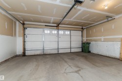 Two-car garage featuring a concrete floor, automatic garage door opener, and integrated windows on the garage door - 