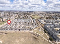 Aerial perspective showcasing a residential community with numerous townhome-style properties - 
