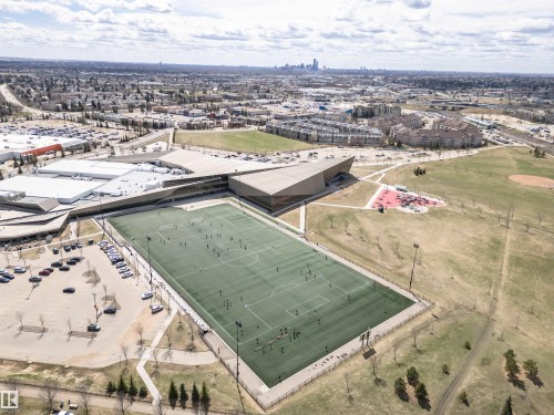 Large recreational facility featuring an artificial turf sports field, surrounding green spaces, and a modern building structure - 110 3625 144 Avenue, Edmonton, AB - Outdoor With View