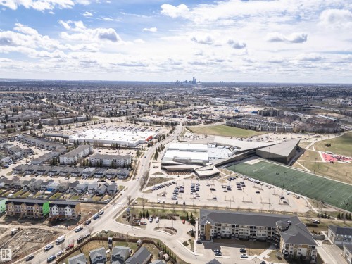 Aerial perspective showcasing a mixed-use neighborhood with residential properties, commercial retail centers, and recreational facilities - 110 3625 144 Avenue, Edmonton, AB - Outdoor With View