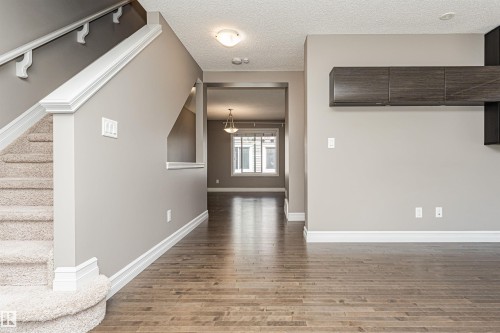 Wood-finish flooring throughout the main area - 110 3625 144 Avenue, Edmonton, AB - Indoor Photo Showing Other Room