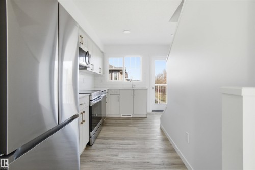 Contemporary kitchen featuring a stainless steel refrigerator, microwave, and range - 64 17832 78 Street, Edmonton, AB - Indoor Photo Showing Kitchen