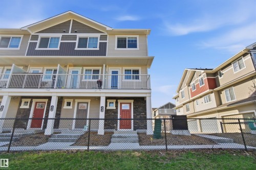 Modern townhome exteriors featuring multiple balconies, mixed-material siding, and vibrant red entry doors - 64 17832 78 Street, Edmonton, AB - Outdoor With Balcony With Facade