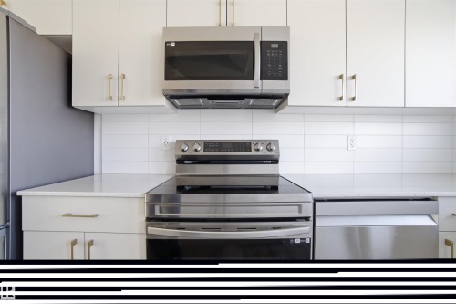 Kitchen featuring stainless steel appliances, white cabinetry with gold-tone hardware, and a white subway tile backsplash - 64 17832 78 Street, Edmonton, AB - Indoor Photo Showing Kitchen With Upgraded Kitchen