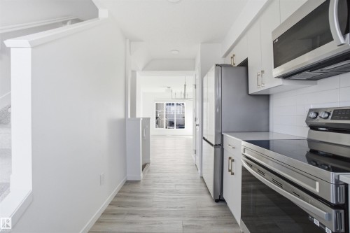 Galley kitchen with white cabinetry and stainless steel appliances - 64 17832 78 Street, Edmonton, AB - Indoor Photo Showing Kitchen