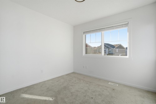 Light-filled room featuring a large window with horizontal blinds, neutral wall paint, and plush carpeting - 64 17832 78 Street, Edmonton, AB - Indoor Photo Showing Other Room