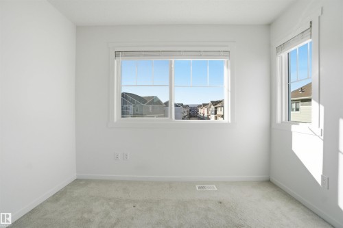 Interior room featuring light gray carpet flooring, white painted walls, and white window trim - 64 17832 78 Street, Edmonton, AB - Indoor Photo Showing Other Room