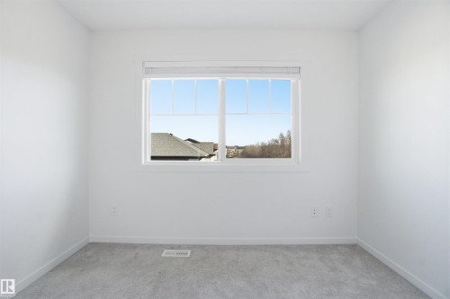 Neutral-toned room featuring a large window, white walls, and light gray carpet - 64 17832 78 Street, Edmonton, AB - Indoor Photo Showing Other Room