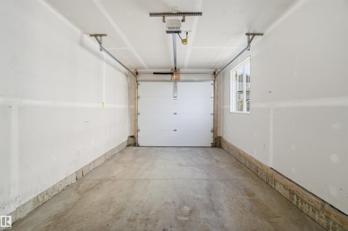 Spacious garage featuring a concrete floor, white walls, and a single window for natural light - 64 17832 78 Street, Edmonton, AB - Indoor Photo Showing Garage