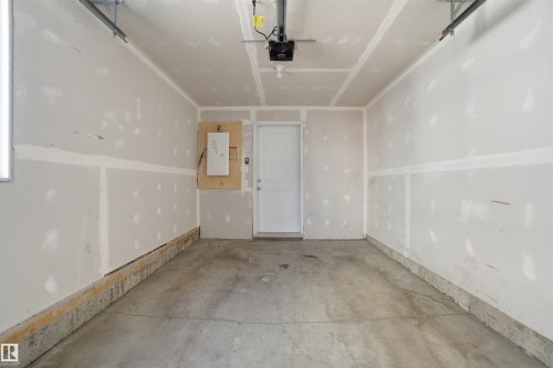 Garage interior featuring a concrete floor, drywall walls, and an overhead garage door opener - 64 17832 78 Street, Edmonton, AB - Indoor Photo Showing Garage