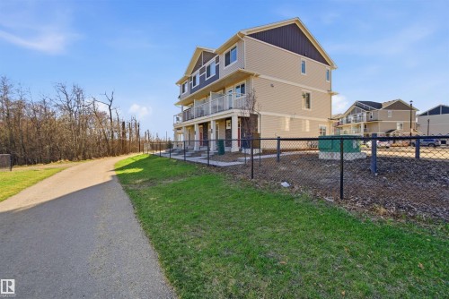 Three-story exterior featuring tan siding, dark brown gables, and individual balconies with glass railings - 64 17832 78 Street, Edmonton, AB - Outdoor With Balcony